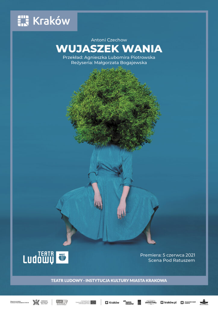 Plakat do spektaklu Śmierć komiwojażera. Druk pionowy z ramą będącą identyfikacją miejską, w lewym górnym rogu logo miasta Krakowa u dołu napis „Teatr Ludowy Instytucja Kultury Miasta Krakowa”. Pod napisem logotypy partnerów i sponsorów Teatru. Po środku plakatu zdjęcie kolaż graficzny. Niebieskie tło. Aktorka w niebieskiej sukience w powie siedzącej stoi na palcach. Zamiast głowy w fotomontażu jest korona drzewa gęba zielona.