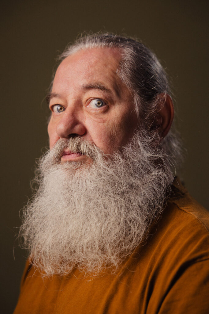 Zdjęcie półprofil portretowe aktora Kajetana Wolniewicza, poważna twarz, bliski kadr.