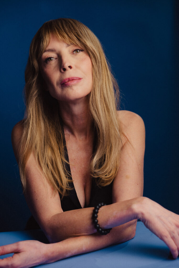 Zdjęcie portretowe aktorki Katarzyny Tlałki, poważna twarz, ręce skrzyżowane przed sobą.