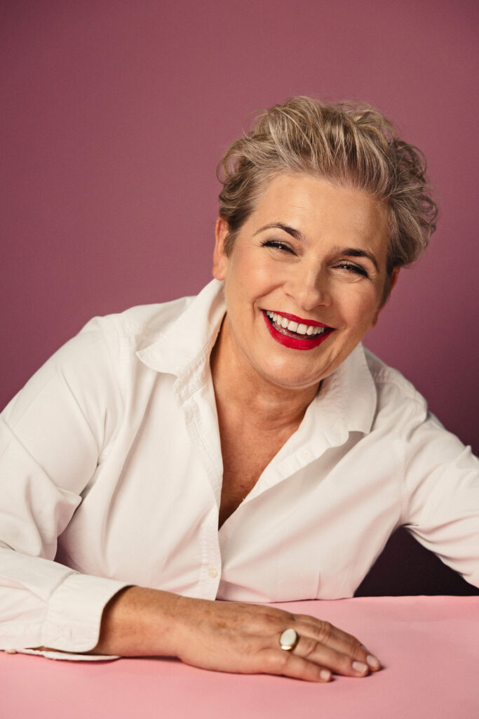 Zdjęcie portretowe aktorki Jagody Pietruszkówny, szeroki uśmiech, ręce przed sobą.