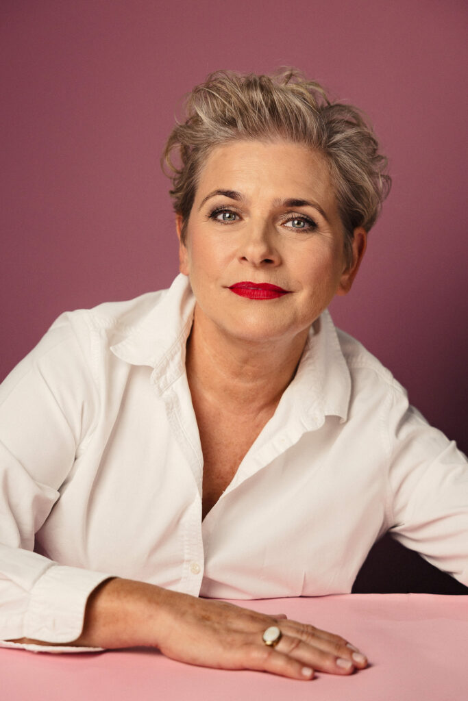 Zdjęcie portretowe aktorki Jagody Pietruszkówny, delikatny uśmiech, ręce przed sobą.