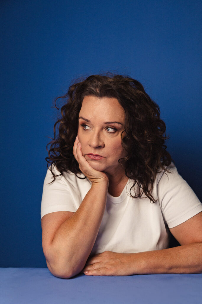 Zdjęcie portretowe aktorki Beaty Schimscheiner, zamyślona, ręka podpiera brodę.