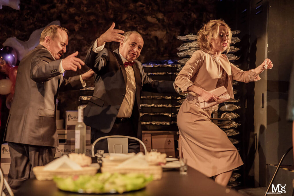 Zdjęcie ze spektaklu Wstyd. Troje aktorów tanecznym krokiem wychodzi ze sceny w prawą stronę.