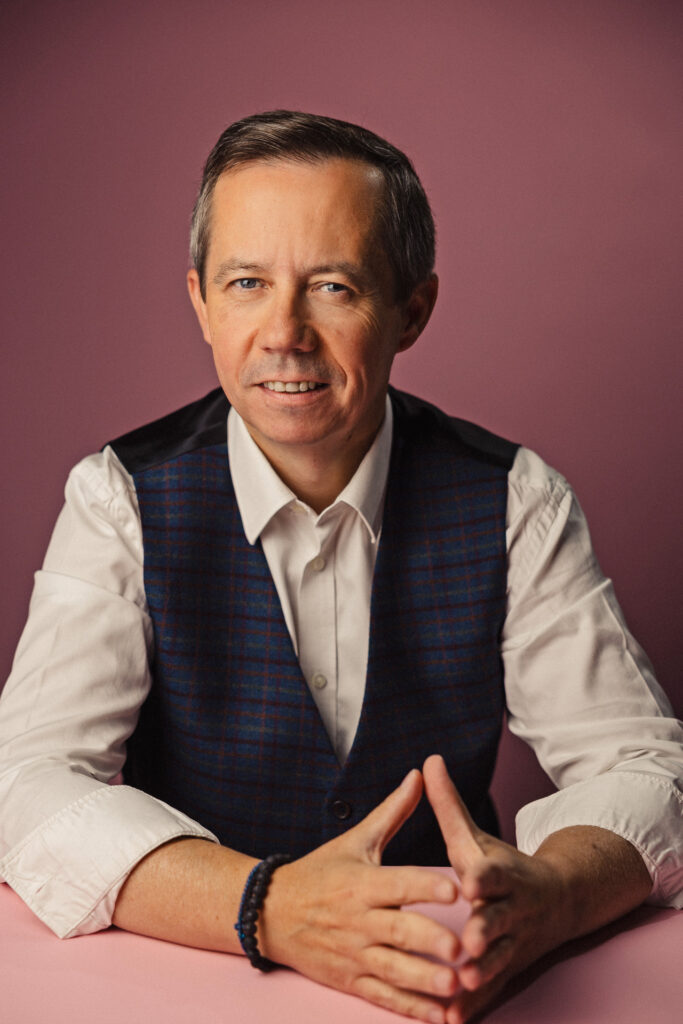 Zdjęcie portretowe zastępcy dyrektora teatru Jerzego Fedorowicza, uśmiechnięta twarz, ręce skrzyżowane przed osobą.