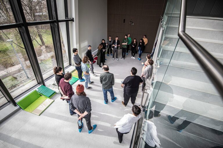 Zdjęcie z realizacji projektu PLAYON. Duża grupa ludzi stoi na foyer teatralnym.