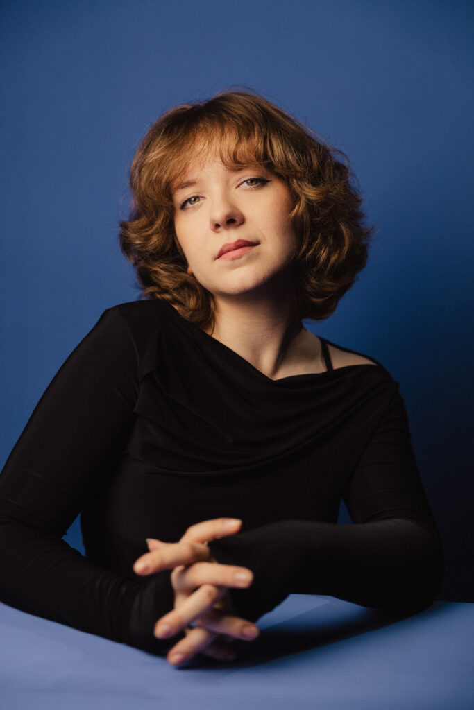 Zdjęcie portretowe aktorki Michaliny Dworzaczek, poważna twarz, ręce splecione przed sobą.