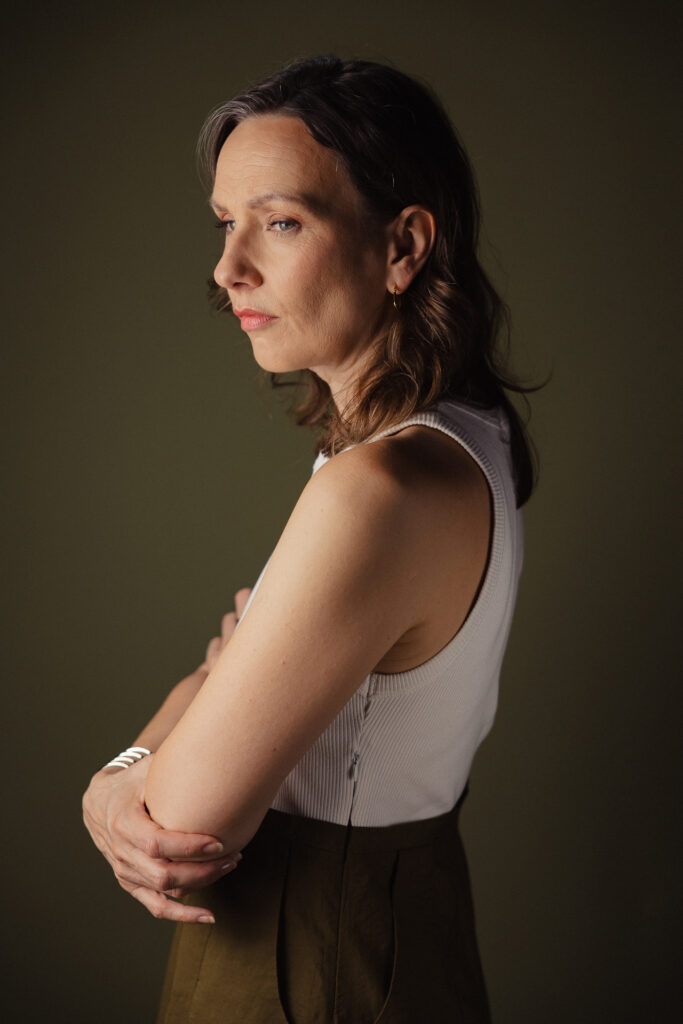 Zdjęcie półprofil portretowe aktorki Patrycji Durskiej, poważna twarz, ręce przy sylwetce