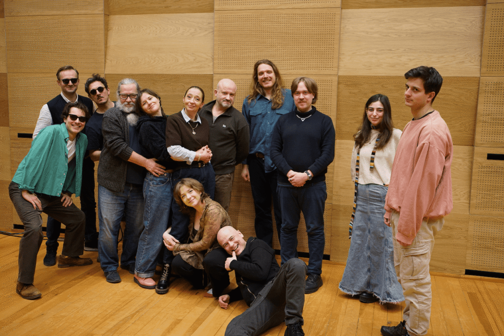 Grupowe zdjęcie aktorów i twórców spektaklu Pan Wołodyjowski. Część osób stoi przytulają się do siebie, uśmiechają się, dwoje kuca. Tło drewniane panele.