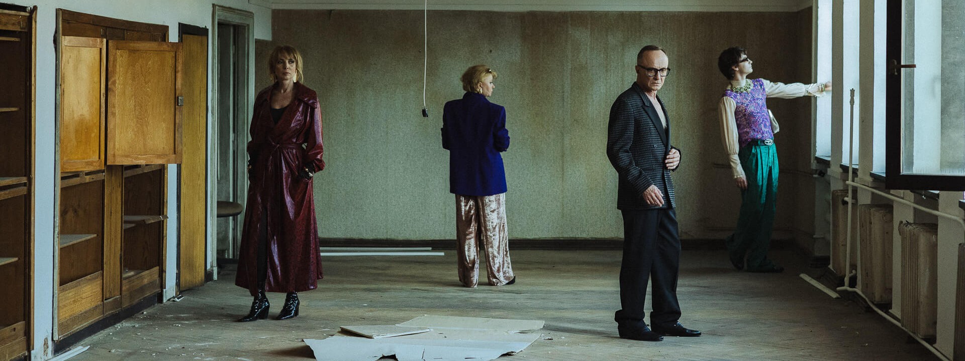 Samotny mężczyzna. czworo aktorów w opuszczonej przestrzeni biurowej. Po lewej pootwierane szafki, po prawej stronie okna